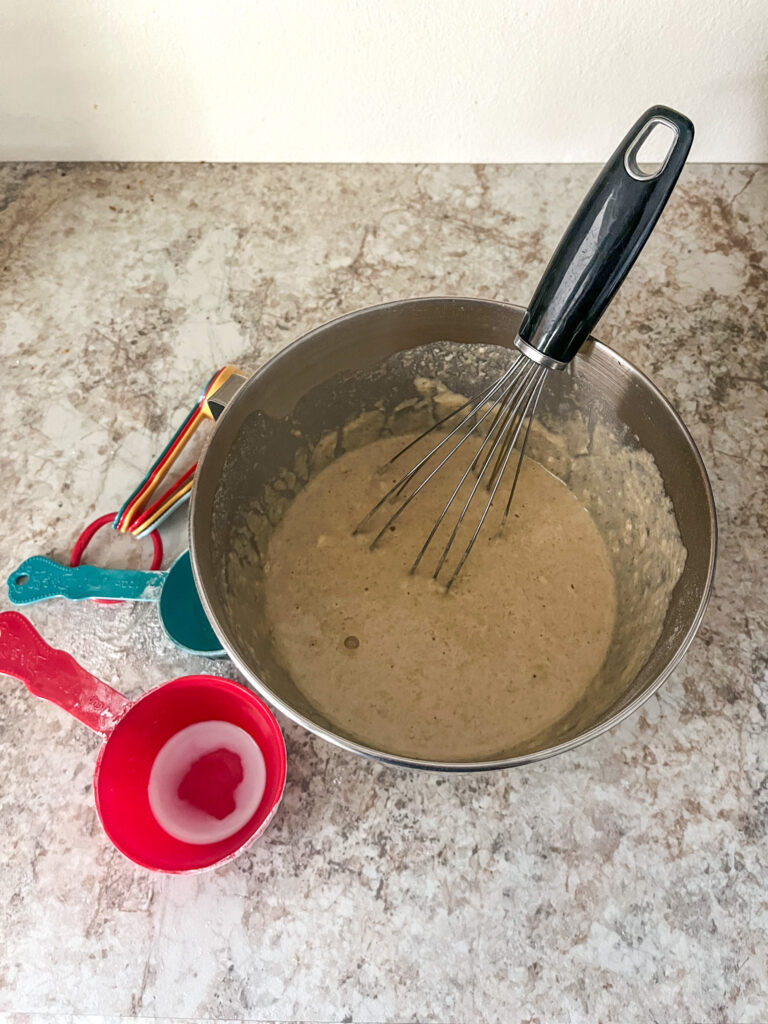 dry and wet ingredients for baking sheet pancake whisked together in a bowl
