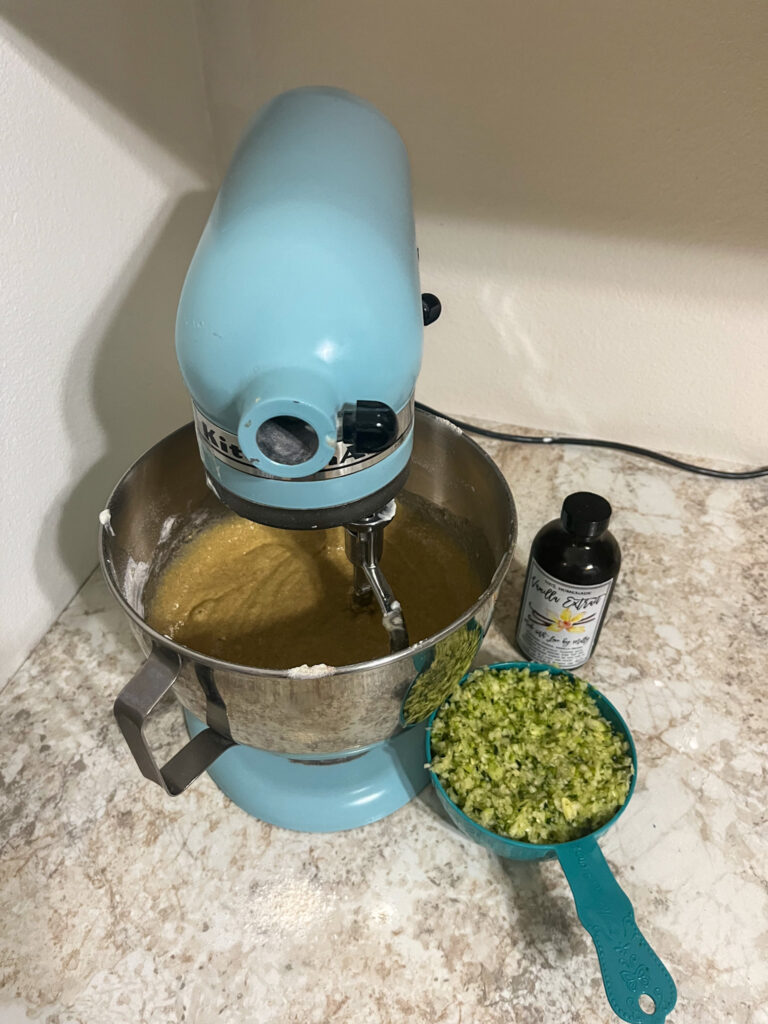 freshly grated zucchini going into zucchini muffin batter