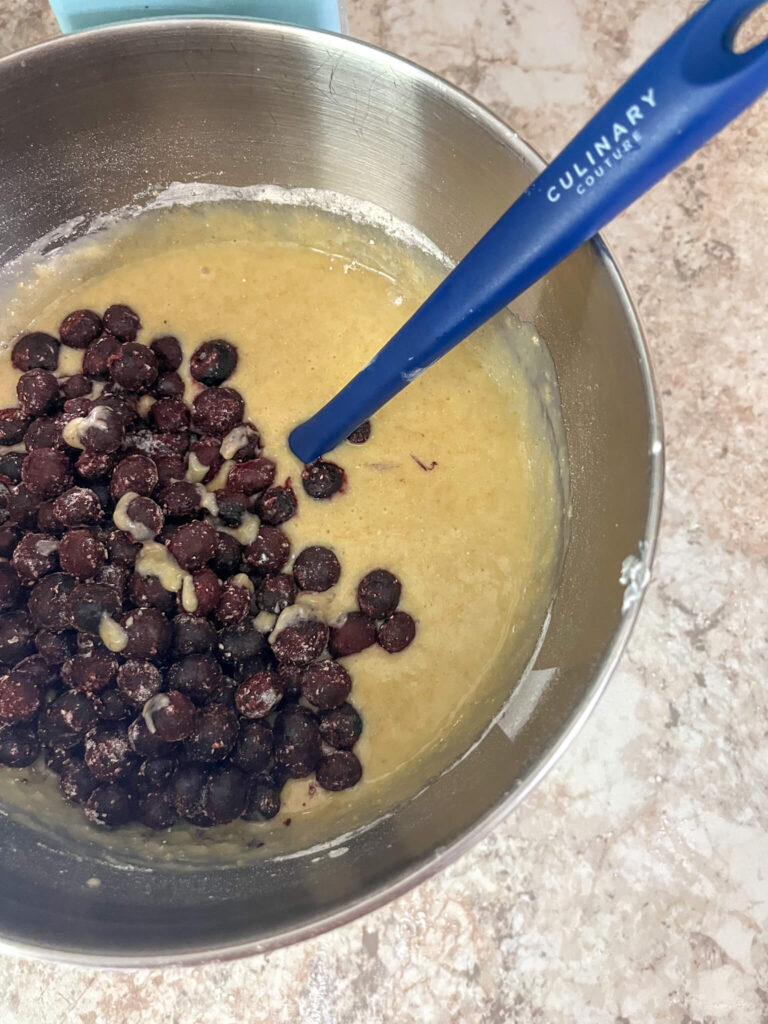 folding blueberries in muffin batter